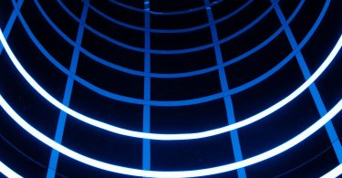Blue-lit tunnel with geometric light patterns, used to represent experimental motion and immersive spatial interaction.