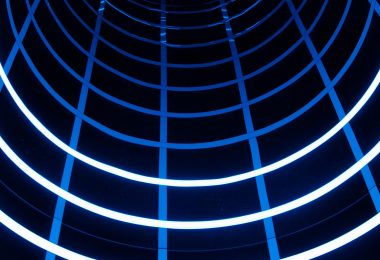 Blue-lit tunnel with geometric light patterns, used to represent experimental motion and immersive spatial interaction.